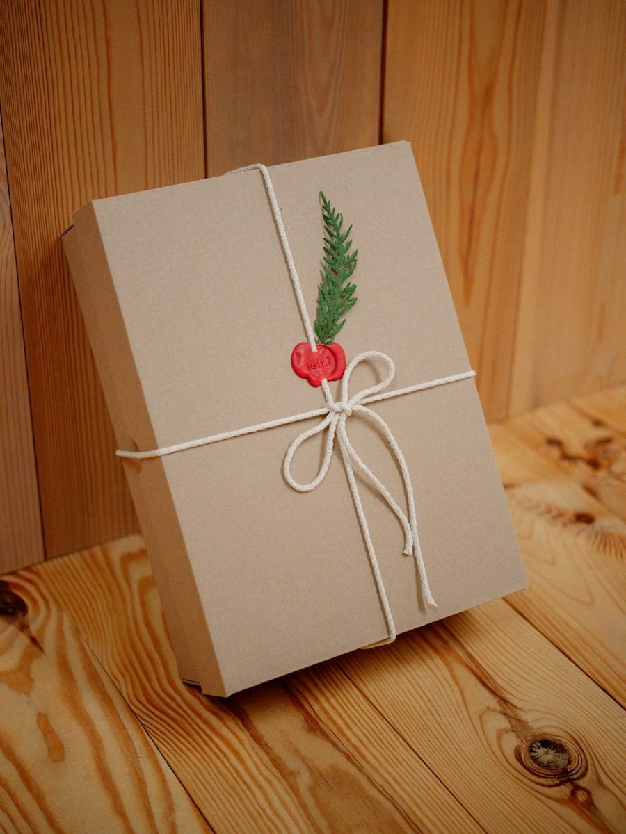 Cadeau emballé dans du papier kraft, noué d'une ficelle avec un brin de sapin